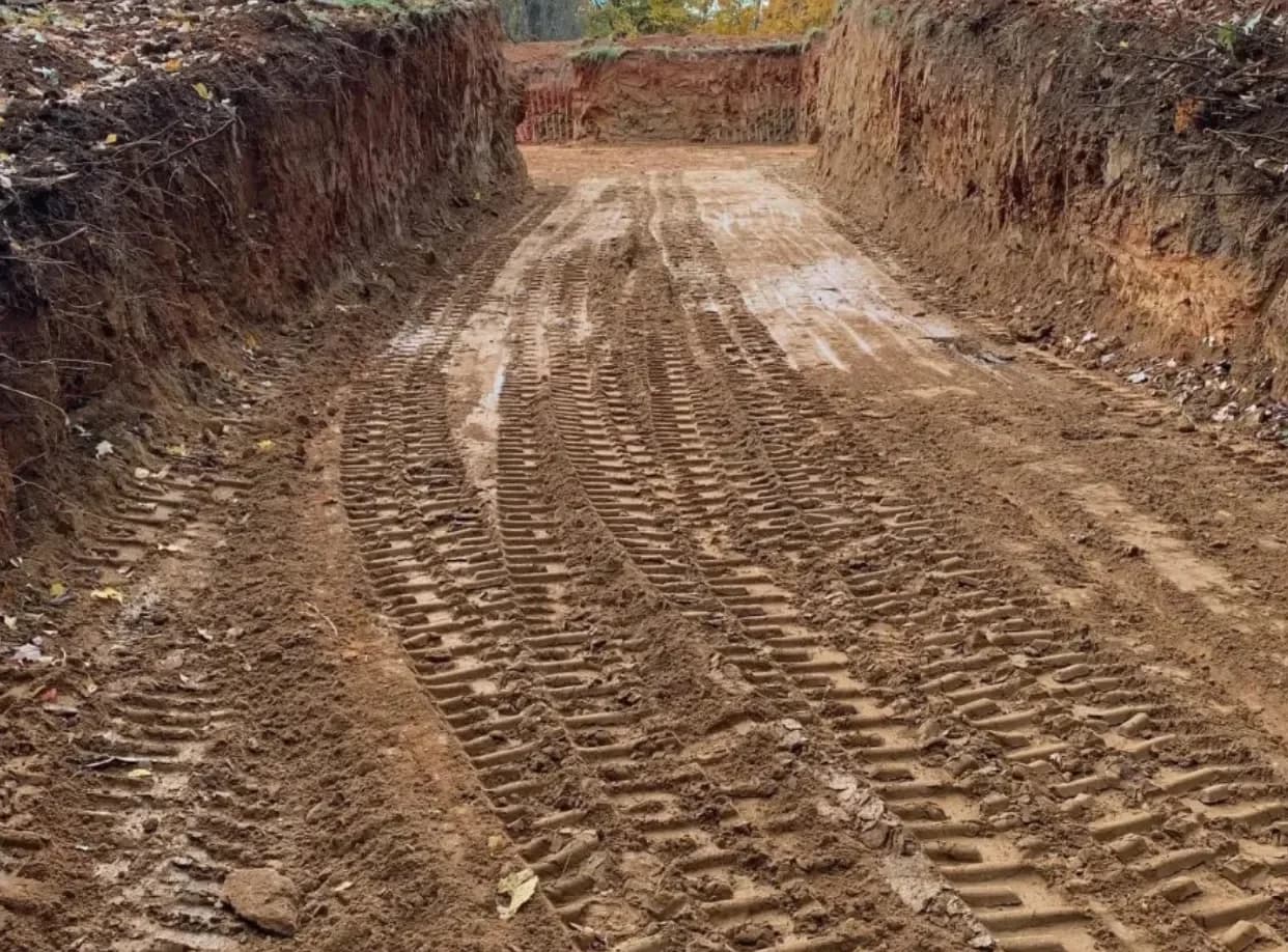 Excavation equipment grading a driveway and building site